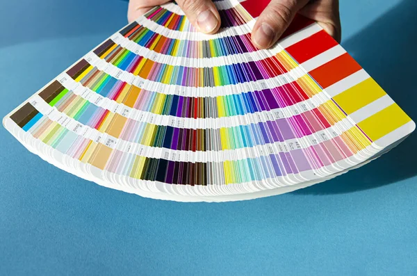 Kolorowa Paleta Kolorystyczna Utrwalonego Zestawu Kolorów Rękach Człowieka Niebieskim Tle — Zdjęcie stockowe