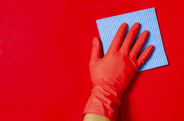 Niebieski dom mycie gąbka w dłoni w czerwonej gumowej rękawicy na czerwonym tle — Zdjęcie stockowe