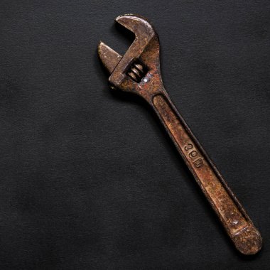 Onarım için paslı ayarlanabilir bir anahtar siyah arka planda yatar. Yakın plan.