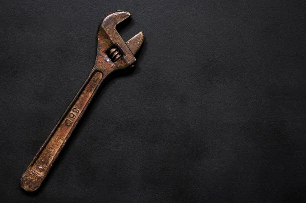 Onarım için paslı ayarlanabilir bir anahtar siyah arka planda yatar. Yakın plan.