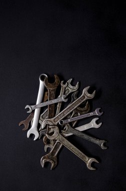 Siyah arka planda deri bir çantanın içinde bir takım tamir aletleri. Farklı boyutlarda anahtarlar