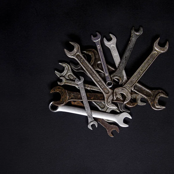 A set of repair tools in a leather case on a black background. Keys of different sizes