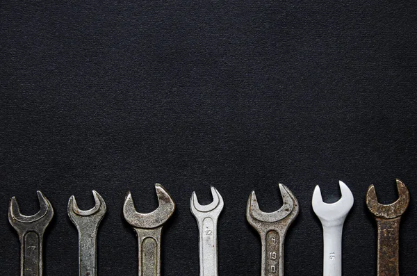 A set of repair tools in a leather case on a black background. Keys of different sizes