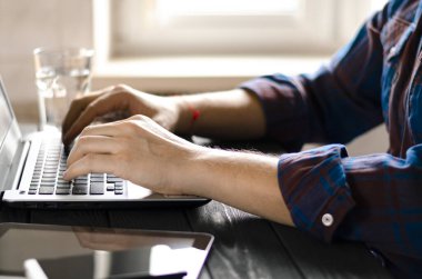 Freelancer koronavirüs salgını sırasında merkezde çalışıyor. Beyaz arkaplan görünümünde boş ekran ile laptop aç