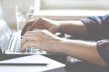 Freelancer koronavirüs salgını sırasında merkezde çalışıyor. Beyaz arkaplan görünümünde boş ekran ile laptop aç