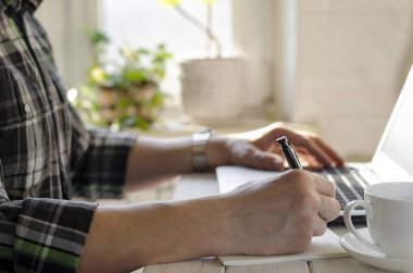 Freelancer koronavirüs salgını sırasında merkezde çalışıyor. Beyaz arkaplan görünümünde boş ekran ile laptop aç