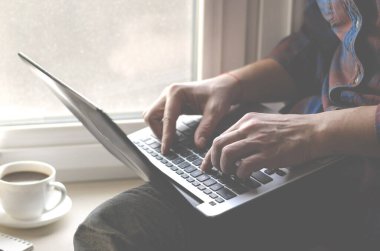 Ofiste dizüstü bilgisayar kullanan bir adam. Klavyede yazan erkek eller. Bilgisayarda iş çalışması