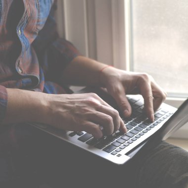 Ofiste dizüstü bilgisayar kullanan bir adam. Klavyede yazan erkek eller. Bilgisayarda iş çalışması