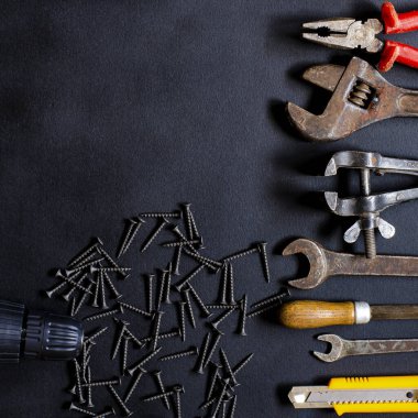 Ev koşullarında tamir ve yeniden yapılandırma için el aletleri siyah arka planda yatar. Boşluğu kopyala