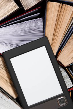 Yalan açık çok renkli kitapları okumaya hazır bir koyu zemin üzerine beyaz bir ekran ile e-kitap yatıyor. yakın çekim