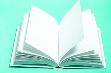Beyaz tasarım kağıdının arkaplanındaki boş kare kataloğun bir kopyası. Açık beyaz bir kitap parlak mavi bir arkaplanda yatıyor.