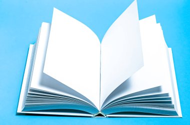 Beyaz tasarım kağıdının arkaplanındaki boş kare kataloğun bir kopyası. Açık beyaz bir kitap parlak mavi bir arkaplanda yatıyor.