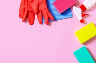 Mutfak, banyo ve diğer odaların farklı yüzeyleri için renkli temizlik seti. Yeşil arka planda mesaj veya logo için boş bir yer. Temizlik hizmeti konsepti. Üst görünüm