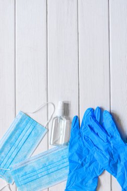 Bir çift ince mavi lateks eldiven ve beyaz arka planda yüz kalkanı. Tek kullanımlık lastik eldiven ve maske. Koruyucu denekler