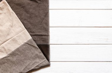 Çok renkli bir bez peçete beyaz ahşap bir arka planda duruyor.