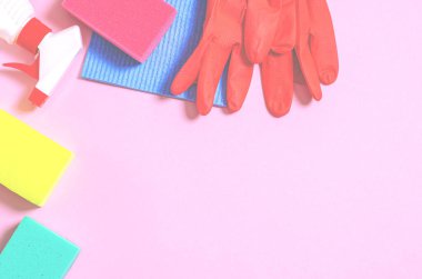 Mutfak, banyo ve diğer odaların farklı yüzeyleri için renkli temizlik seti. Yeşil arka planda mesaj veya logo için boş bir yer. Temizlik hizmeti konsepti. Üst görünüm