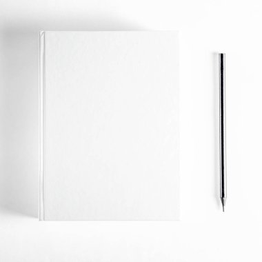 Mockup of closed blank square book and black pencil at white textured paper background. Hardcover Book Mock-Up - Dust Jacket. Wall Background