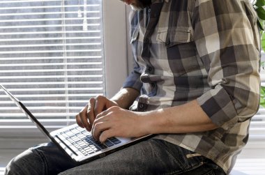 Freelancer koronavirüs salgını sırasında merkezde çalışıyor. Beyaz arkaplan görünümünde boş ekran ile laptop aç