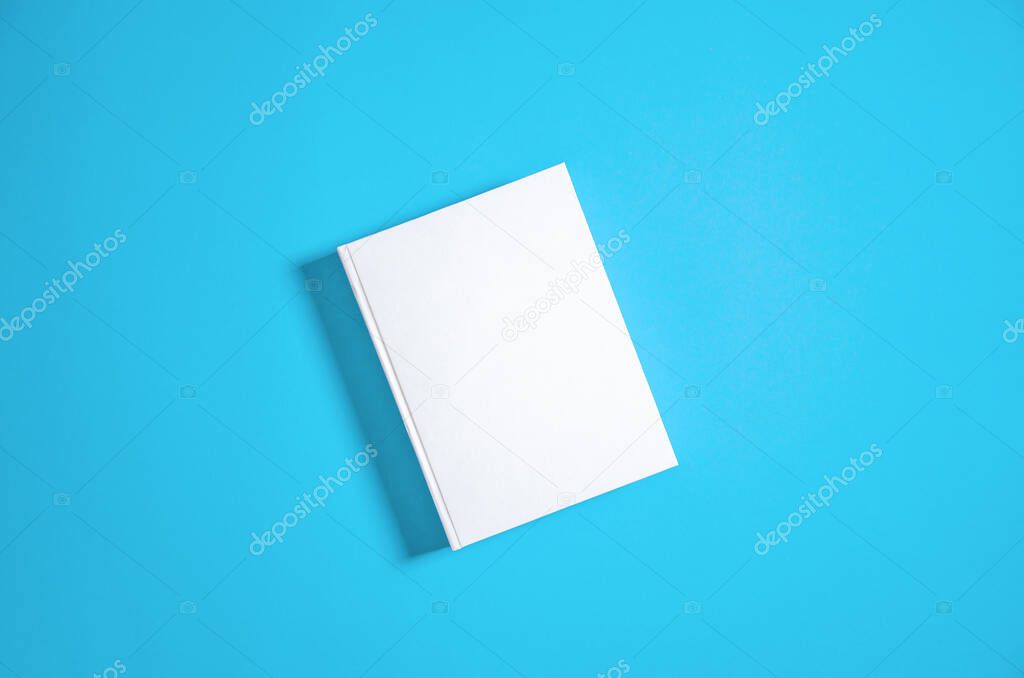 Mockup of closed blank square book at white textured paper background. Blank square cover book template on bright blue background