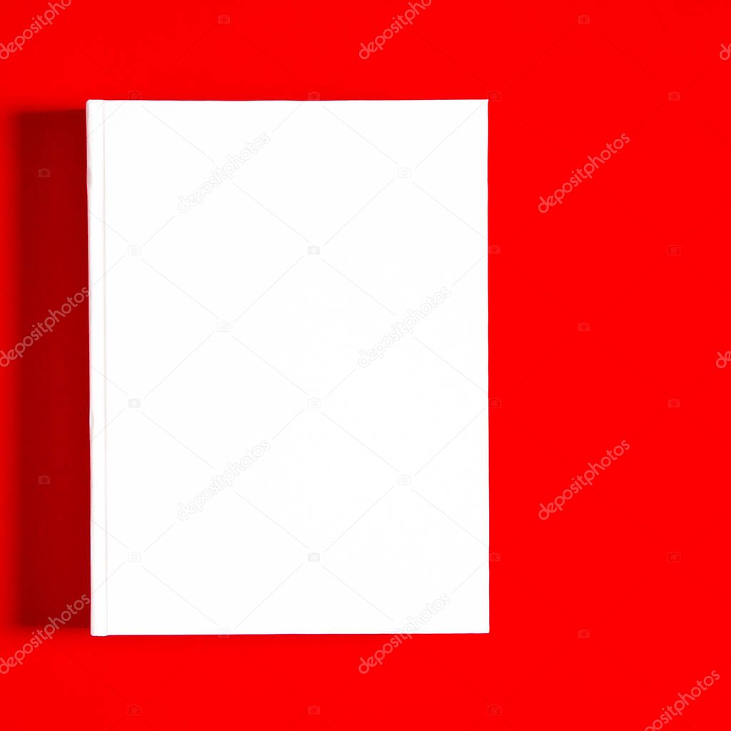 Mockup of closed blank square book at white textured paper background. Blank square cover book template on bright red background