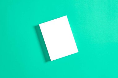 Beyaz desenli kağıt arkaplanda kapalı kare kitabın bir kopyası. Parlak arkaplanda boş kare kapak şablonu