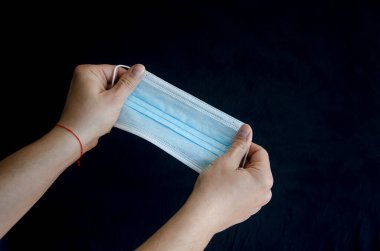 Tıbbi koruyucu mavi maskeler bir adamın elinde. İlaç.