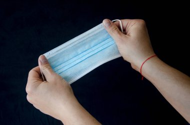 Tıbbi koruyucu mavi maskeler bir adamın elinde. İlaç.