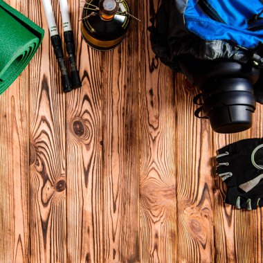 Turist konsepti. Sırt çantası, avlu, İskandinav yürüyüşü için sopalar ve turist gereçleri tahta bir arka planda duruyor.