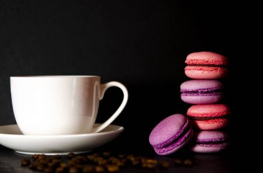 Siyah arka planda beyaz bir fincan kahveli makarna. Tatlılar