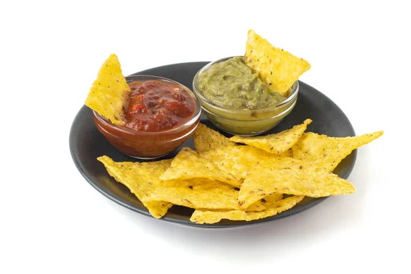 Mexikanska nachos tortilla chips med guacamole och salsa i mörk tallrik. Isolerad på vit bakgrund — Stockfoto