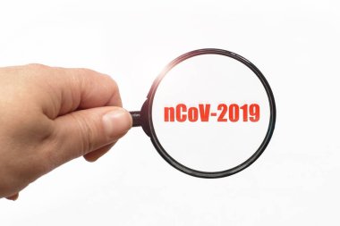 Elde büyüteç ve beyaz arka planda ncov 2019 kelimesi.