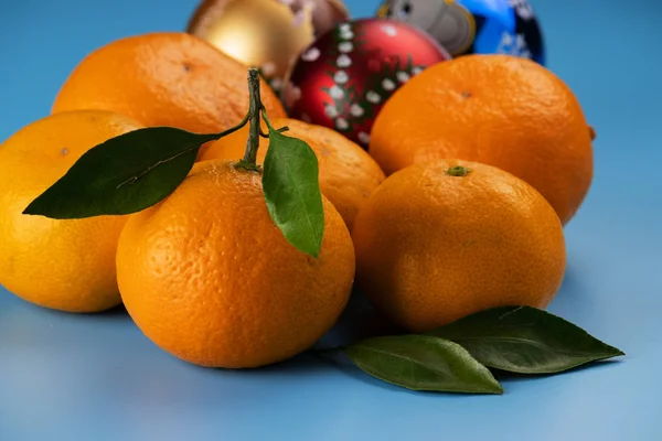 Gelbe und reife Mandarinen auf blauem Hintergrund. — Stockfoto