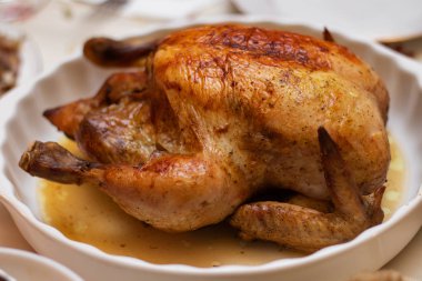 Beyaz bir tabakta soslu fırında tavuk leşi..