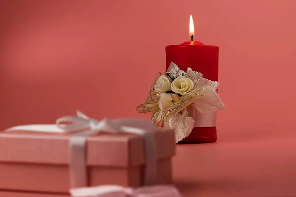 Big red burning candle on a pink background. — Stock Photo, Image