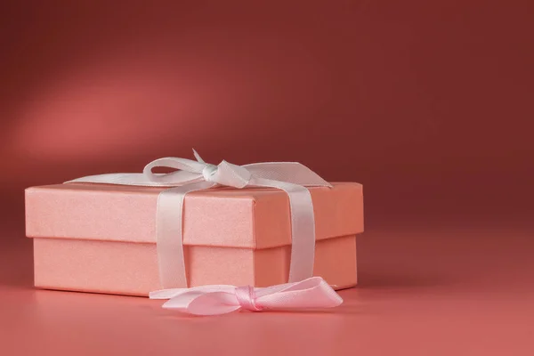 Caja rosa con un regalo y un lazo sobre un fondo rosa . Fotos De Stock Sin Royalties Gratis