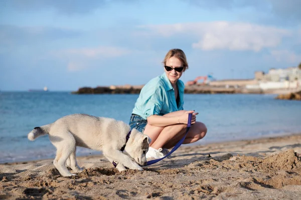 Young Pretty Blond Woman Sitting Beach Sea Holding Her Dog — Stock Photo, Image