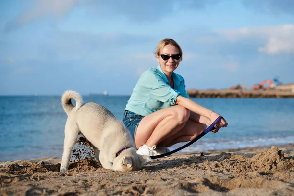 Young Pretty Blond Woman Sitting Beach Sea Holding Her Dog — Stock Photo, Image