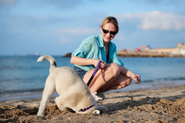 Young Pretty Blond Woman Sitting Beach Sea Holding Her Dog — Stock Photo, Image