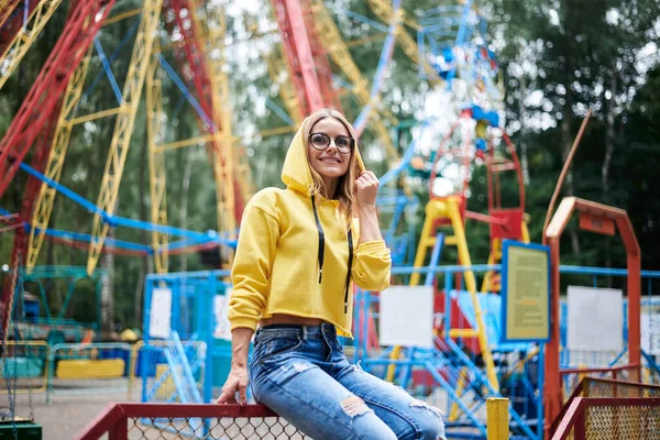 Молодая Блондинка Жёлтой Толстовке Синих Джинсах Проводит Лето Парке Аттракционов — стоковое фото