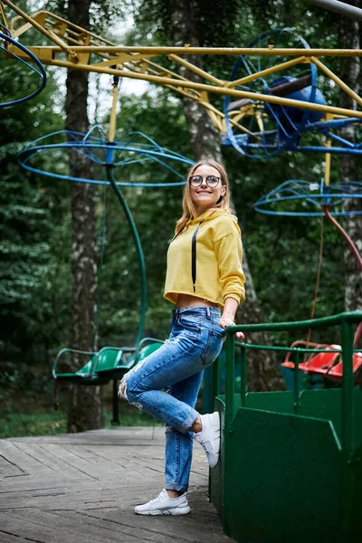 Ung Blond Kvinna Klädd Gul Hoody Blå Jeans Och Glasögon — Stockfoto