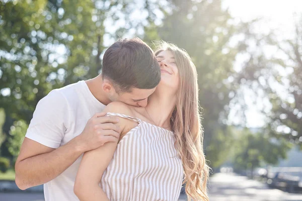 英俊的黑发男子 身穿白色T恤 拥抱和亲吻漂亮的金发女人在条纹整体 年轻夫妇相爱 夏天在绿地公园拥抱 浪漫的关系 情人节 — 图库照片