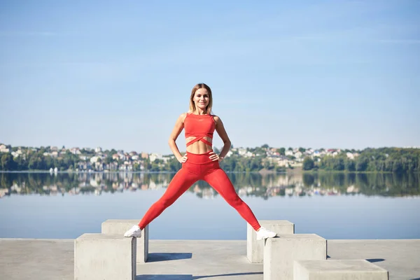 Giovane Donna Bionda Vestita Rosso Fitness Piedi Una Piattaforma Cemento — Foto Stock