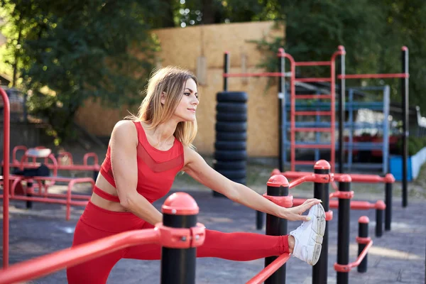 Mujer Rubia Joven Usando Traje Fitness Rojo Que Extiende Patio — Foto de Stock
