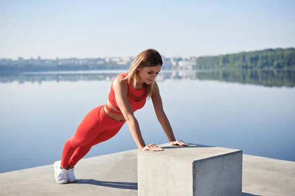 Mulher Loira Jovem Vestindo Roupa Fitness Vermelho Prancha Plataforma Concreto — Fotografia de Stock