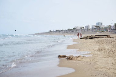 Hayfa / İsrail - 25 Mayıs 2019: Hof Hacarmel plajı sabah. İnsanlar yazın şehir plajında yürüyor ve yüzüyorlar. Deniz kıyısı. Açık bej rengi kum ve mavi gökyüzü olan okyanus manzarası.