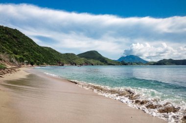 St. Kitts Adası / Saint Kitts ve Nevis - 29 Kasım 2016: Arkasında dağlar olan siyah kum plajı manzarası. Güzel seyahat filmi.