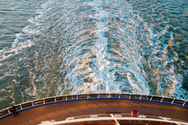 Yolcu gemisinin arka güvertesinden bakıldığında, gün batımında okyanusta köpüklü izler ve dalgalar bırakılır. İnanılmaz doğal arkaplan manzarası. Seyahat yolculuğu fotoğrafı..