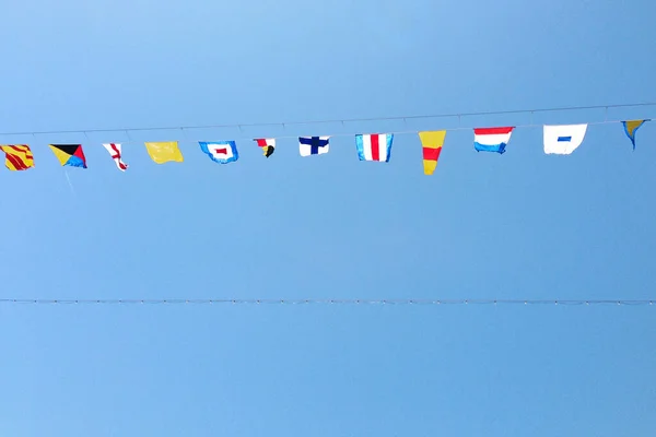 Różne Kolorowe Flagi Związane Liną Tle Jasnoniebieskiego Nieba Flagi Morskie — Zdjęcie stockowe