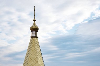 Mavi gökyüzünün önündeki Ortodoks kilisesinde haçlı altın kubbe. Hıristiyanlık dini, Ortodoks tapınağı.