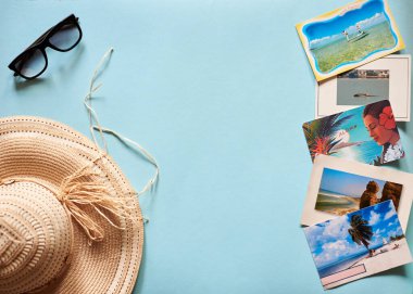 Ternopil / Ukrayna-Apr 13 2020: Hasır şapka, siyah güneş gözlüğü ve renkli kartpostallar da dahil olmak üzere yaz tatili aksesuarlarının düz resmi. Yaz tatili, seyahat, turizm konsepti.